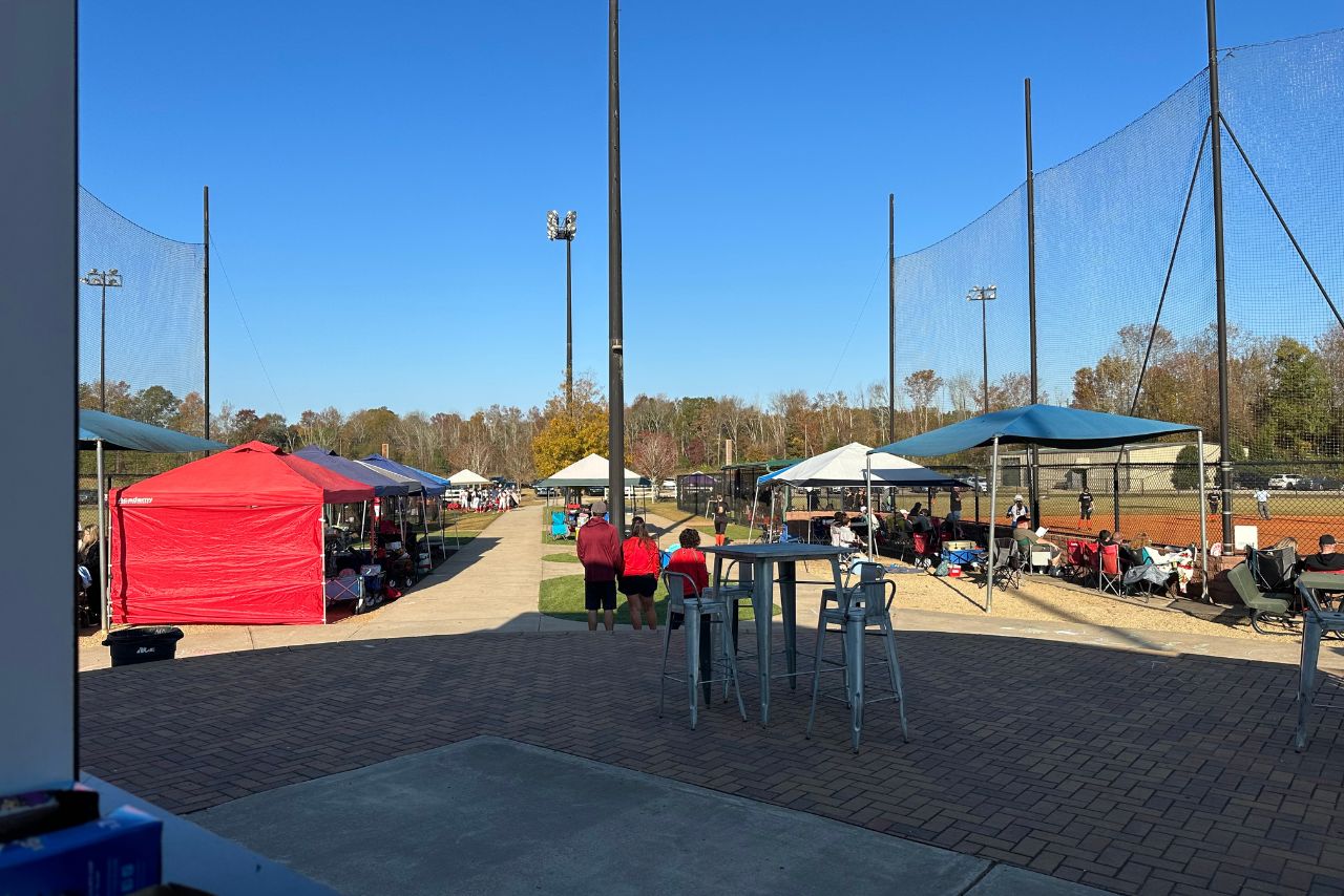 an event at mulberry river sports complex with people standing near the baseball fields with tents and concessions in the backrgound